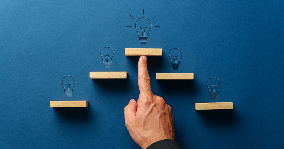 Mano di un uomo che indica una composizione di lampadine come segno di gestione dell'innovazione